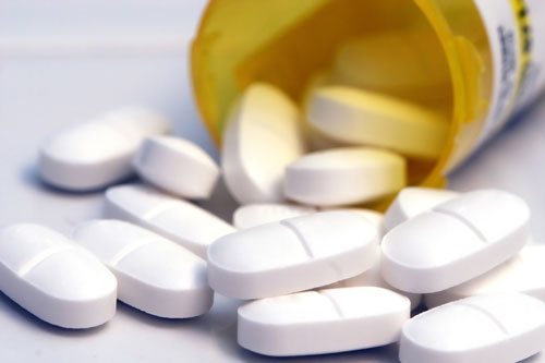 oval pills spilling from a pill bottle